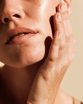 extreme closeup of a skincare model's fingers on her cheek