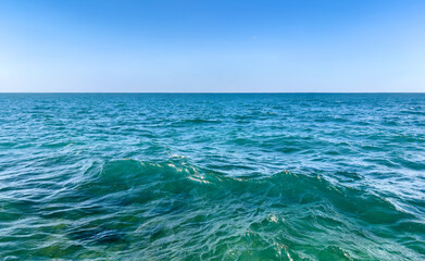 Obraz premium Close-up of calm emerald turquoise sea under clear blue sky on a sunny day. sea water surface. minimalist seascape