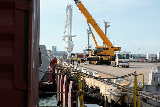 Port loading with crane and workmen