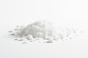 Fototapeta premium A small pile of white granulated sugar sits on a white background.