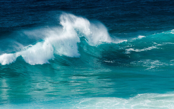 Wind blowing the top off a wave