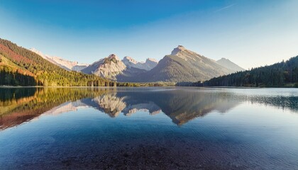 Obraz premium Serene mountain range reflected in crystal clear lake, showcasing nature beauty