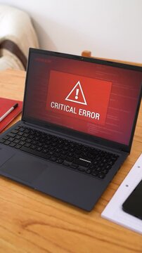 Laptop with critical error message on red screen. Concept of system alert. Vertical orbiting shot.