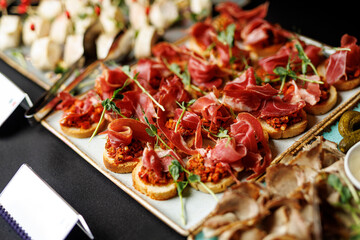 Italian antipasto platter features a variety of cured meats, cheeses, and appetizers artfully arranged on trays.