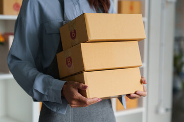 Entrepreneurship and Package Handling. A woman carrying multiple packages for her online store.