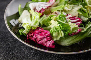 Salad mixed leaves iceberg, batavia, lettuce, radicchio, romano, frisee appetizer vegetables dish organic fresh tasty gourmet food background on the table copy space keto paleo diet vegetarian vegan