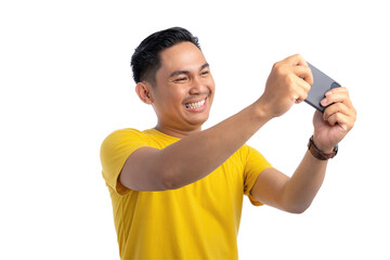 Excited young Asian man using smartphone for playing mobile game with happy expression isolated on transparent background