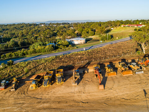 Machinery on worksite lined up in morning light ready to continue construction on bypass road