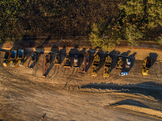 Machinery on worksite lined up in morning light ready to continue construction on bypass road