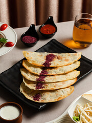 Azerbaijani stuffed flatbread - Qutab on black tray