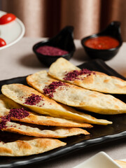 Azerbaijani stuffed flatbread - Qutab on black tray