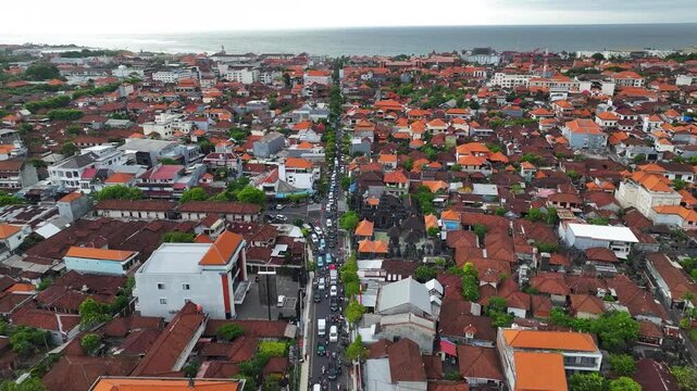 Busy road to Kuta Beach in Bali, aerial view cityscape with the buildings, Indonesia.