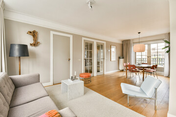 A stylish modern living room features soft-colored walls, contemporary furniture, and elegant decor, creating a warm and inviting atmosphere.