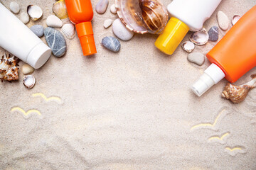 Bottles of sunscreen (sun cream) on the sand background with seashells. Sun tan, summer skin care, photoaging, skin health, UV protection. Copy space. Empty place.