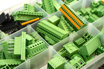 Screw terminal blocks. Components for electrical equipment. Terminal blocks inside plastic container. Cells with connectors for boards. Screw terminal blocks of different types. Wire connectors