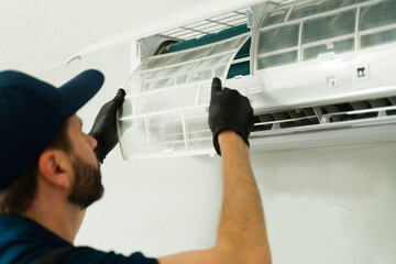 Closeup of a technician cleaning air conditioning filter during maintenance service