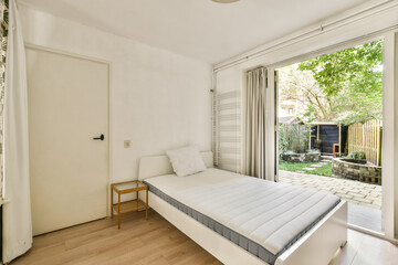 Bright and spacious bedroom featuring minimalistic furniture design, large windows with a view of nature, and a clean aesthetic for a serene atmosphere.