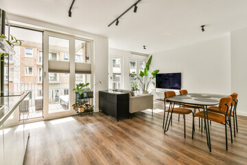 A bright, modern living room featuring large windows that provide ample natural light, contemporary furniture, and a welcoming atmosphere.