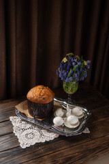 Traditional Easter Cake and White Eggs with Gold Leaf on Rustic Table with Spring Flowers