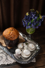 Traditional Easter Cake and White Eggs with Gold Leaf on Rustic Table with Spring Flowers