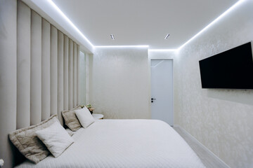 A cozy bedroom with a comfortable bed and a wallmounted TV