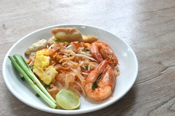 Pad Thai stir fried rice noodles with shrimp and egg on plate 