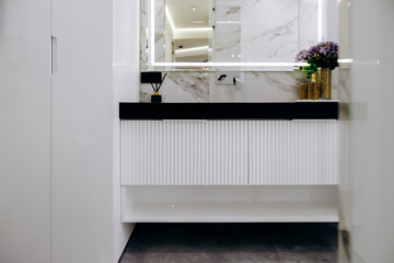 A beautifully designed bathroom with a sink, mirror, and flowers