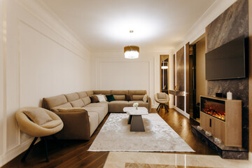 This living room has a cozy couch, chair, TV, and warm fireplace