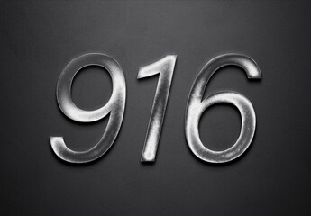Chrome metal 3D number design of 916 on grey background.