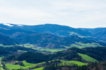Obraz premium Breathtaking panorama of lush green valleys and rolling hills under a bright sky in the Black Forest region during early springtime