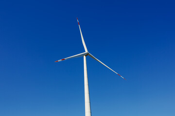 Wind turbines generating energy against a clear blue sky. Wind turbines generating clean renewable energy for sustainable development