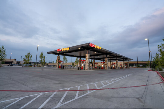 HEB Fuel gas station at dawn withilluminated signs  and dispansing machine, I-10  freeway overpass in the background, Fair Oaks, Texas