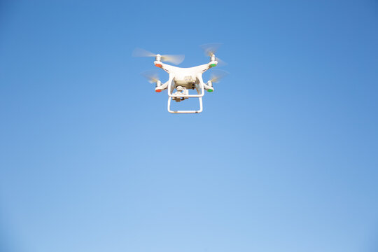 White drone flying in blue sky