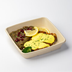 Chicken with sauce, broccoli and lemon with side dish