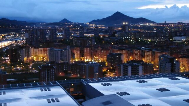 BEC Bilbao Exhibition Centre rooftop, Bizkaia Tower, cityscape at blue hour, City lights, mountains in background, Barakaldo, Basque Country, Spain. Aerial drone