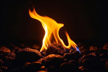 flames are lit on a pile of rocks in the dark