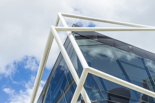 Looking up at a modern metal framework around a glass sided building