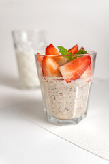 Healthy chia pudding in a glass with fresh strawberries on a light background. Healthy eating. Diet.