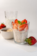 Healthy chia pudding in a glass with fresh strawberries on a light background. Healthy eating. Diet.