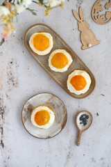 Lemon cupcakes with cream cheese, apricot and poppy seed. Cupcake in form of Fried Egg on a stone background. Easter eggs. Easter holiday and festive food.