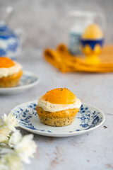 Lemon cupcakes with cream cheese, apricot and poppy seed. Cupcake in form of Fried Egg on a stone background. Easter eggs. Easter holiday and festive food.