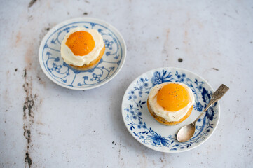 Lemon cupcakes with cream cheese, apricot and poppy seed. Cupcake in form of Fried Egg on a stone background. Easter eggs. Easter holiday and festive food.