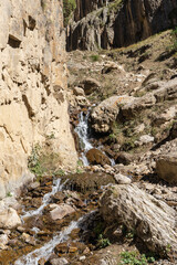 Kabardino-Balkaria. Chegemsky Reserve. Autumn 2024. Stormy and foaming transparent waters of mountain river Abai-Su flow in thin streams between stones and boulders created by nature.