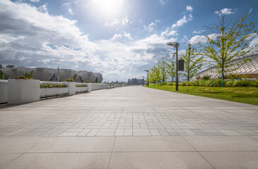 Empty stone tile walkway and skyline in a modern city park.