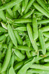 Fresh pea pods as background. Top view.