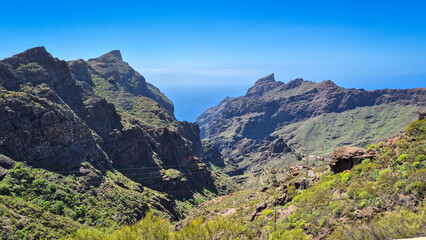Naklejka premium Breathtaking panorama of masca gorge, showcasing tenerife's volcanic formations and the vast atlantic ocean under a clear blue sky