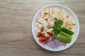 Garlic fried rice topped with steamed crab meat, shallots, cucumber and red chili peppers  on wooden table, Top view.