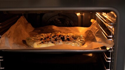 Delicious fruit pie baking in oven on baking sheet