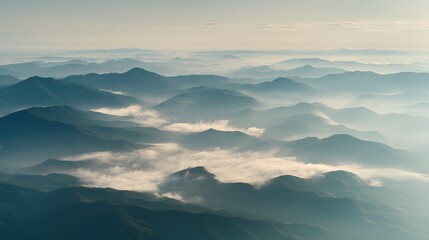 Aerial view of the foggy mountains at sunrise. The panorama of cascading mountains and a sea of clouds in the Chinese art style is reminiscent of National Park Award winning photographs.