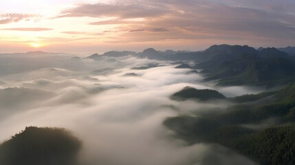Fototapeta premium Aerial view of the foggy mountains at sunrise. The panorama of cascading mountains and a sea of clouds in the Chinese art style is reminiscent of National Park Award winning photographs.